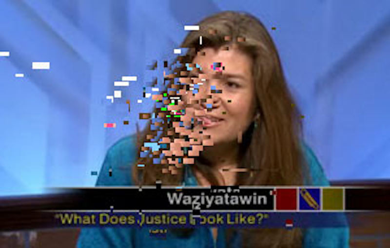 ID: A woman on a televiison programme. The left side of her face is pixelated due to poor reception. The caption under her reads 'What Does Justice Look Like?'.